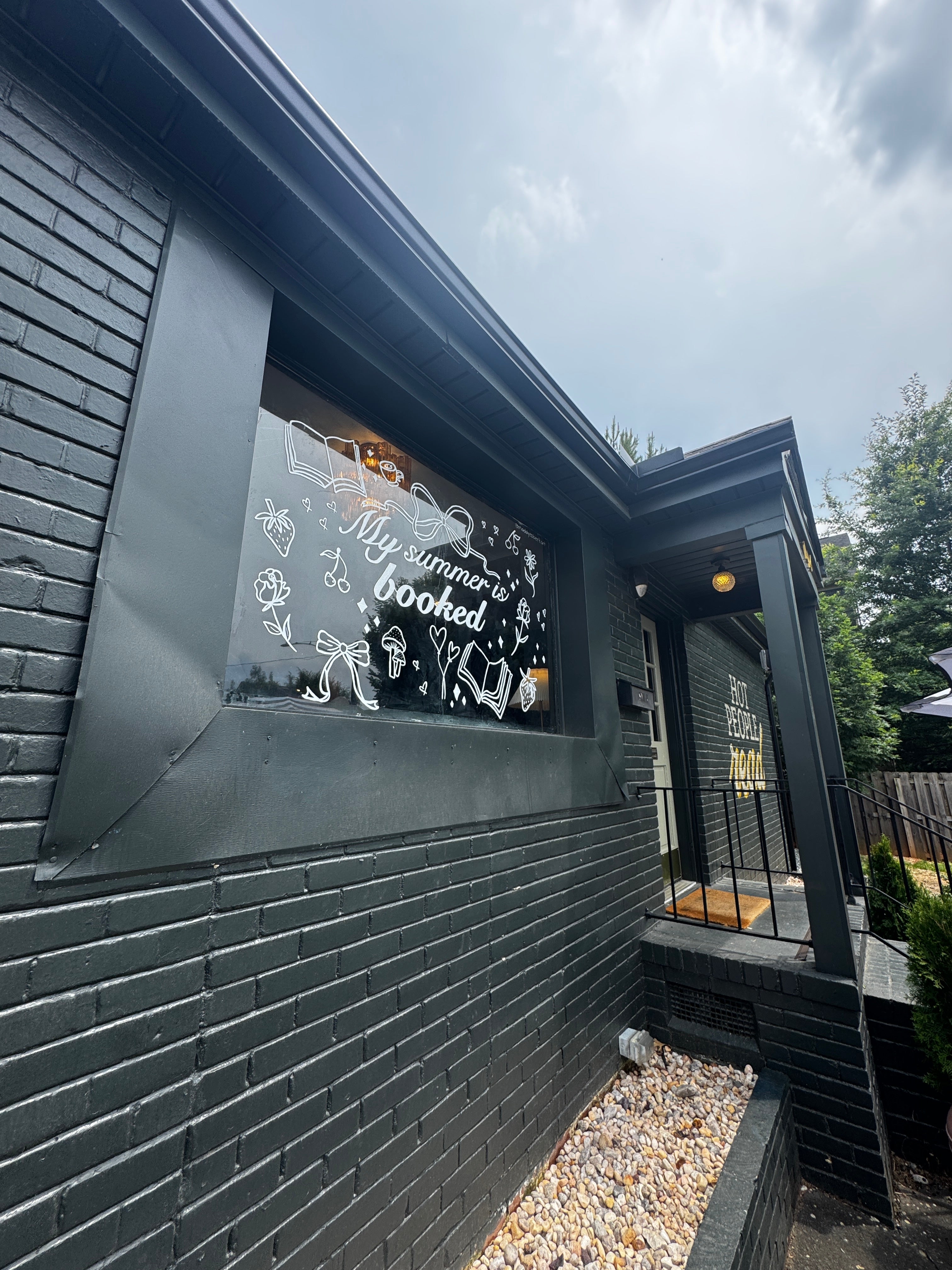 Decorative glass painting mural panel with text and designs on a wooden deck for a book store